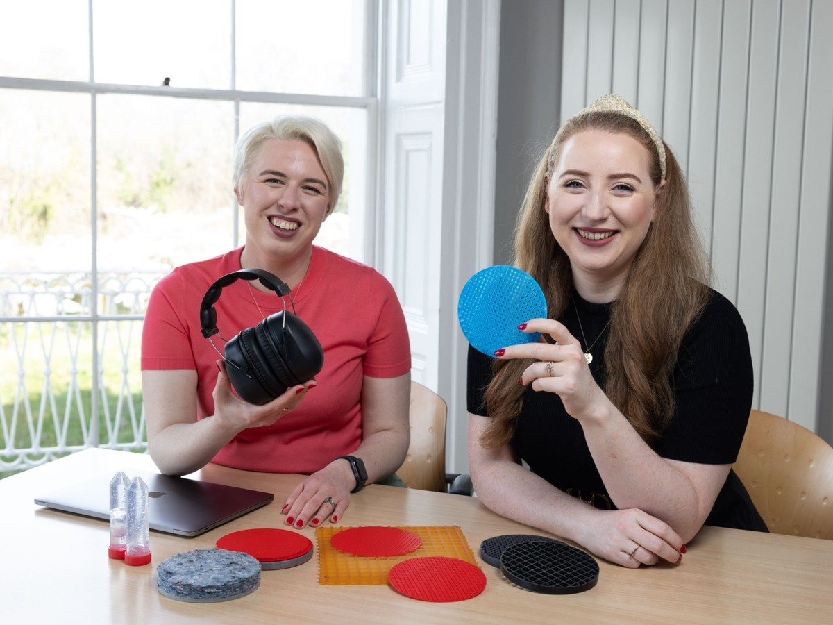Two young to middle-aged white women holding colourful discs in an office setting.