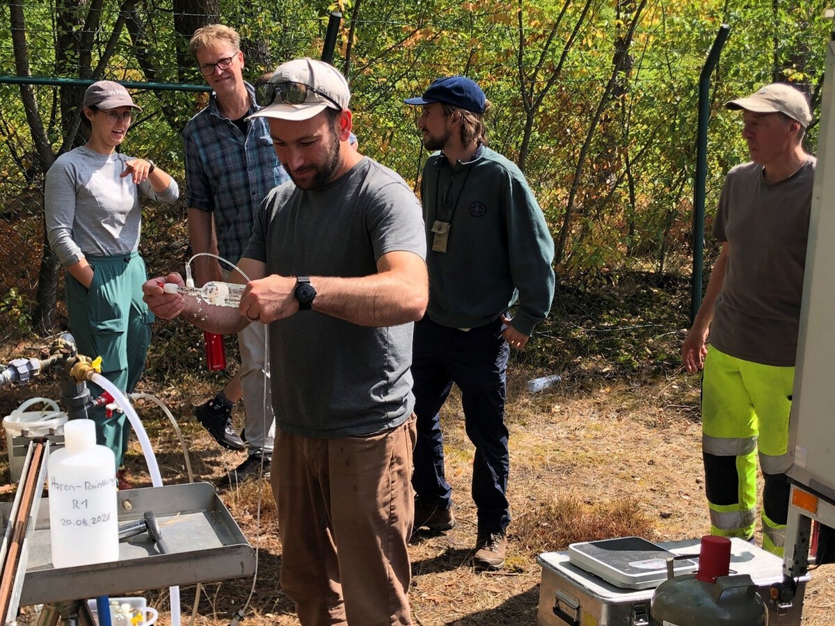 A group of people in a forest with research equipment.