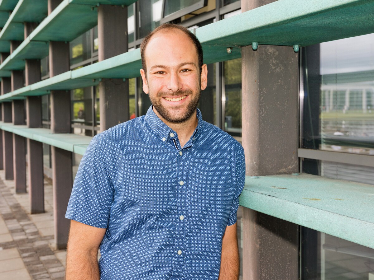 A man in a blue shirt, smiling.