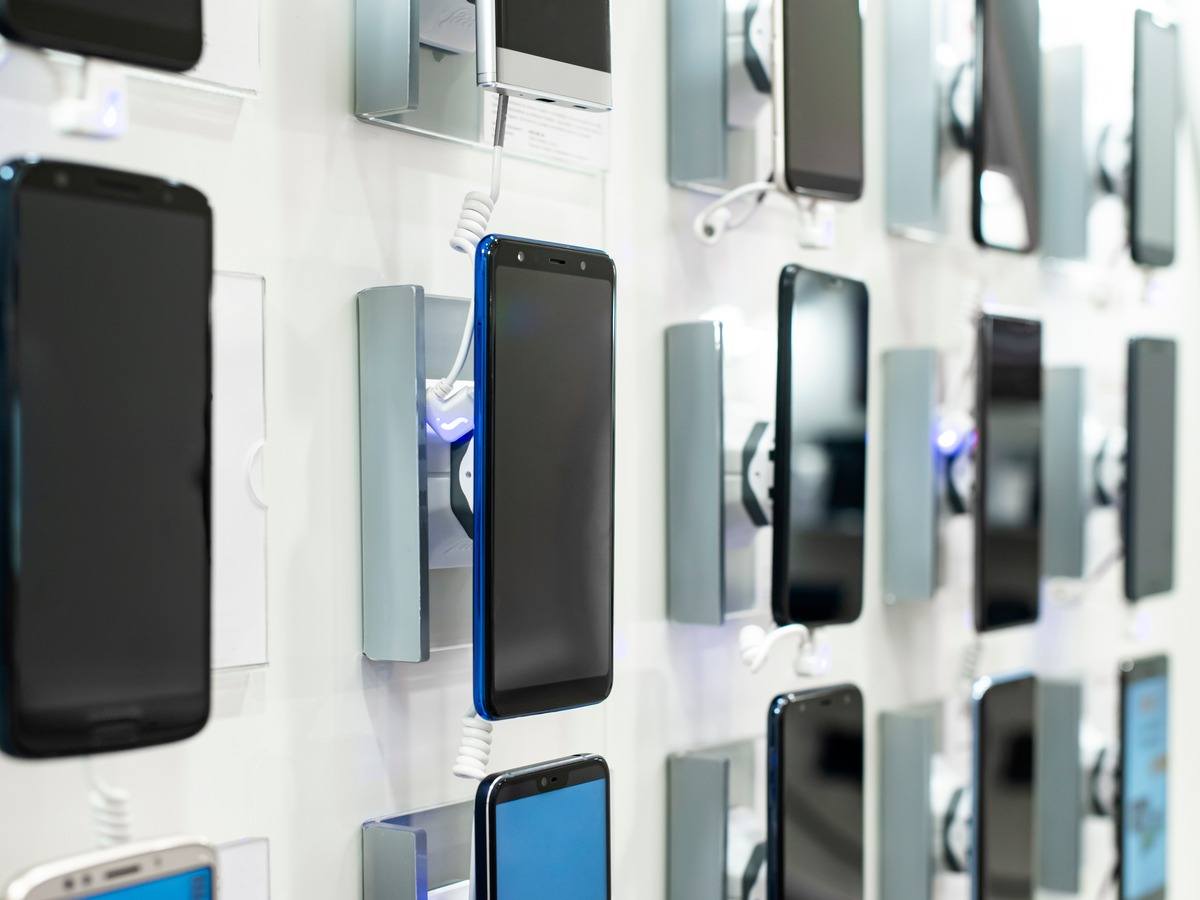 Smartphones mounted on a white wall.