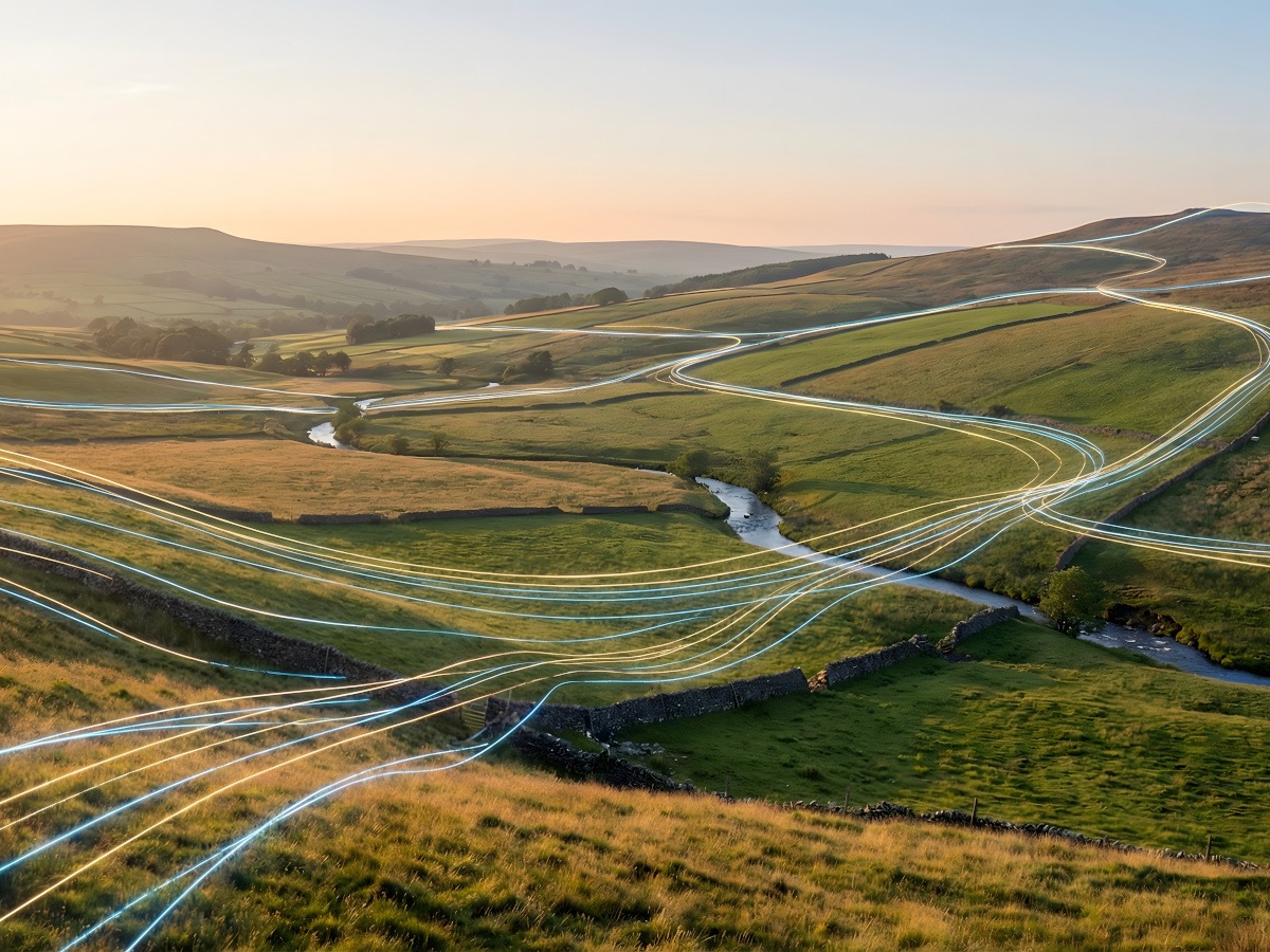 A picture of green hills and fields with digital blue lines representing connectivity flowing over them.