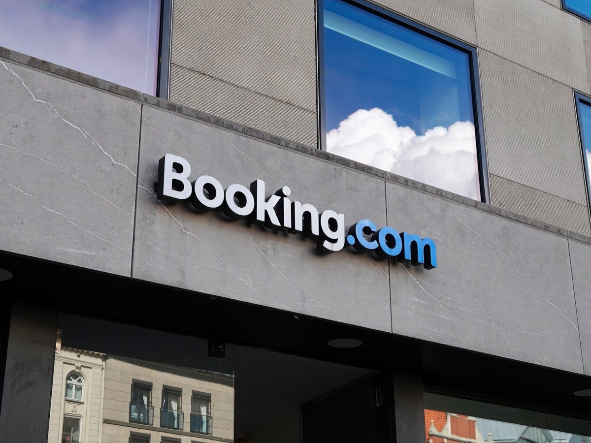 The Booking.com blue and white logo on a grey concrete building.