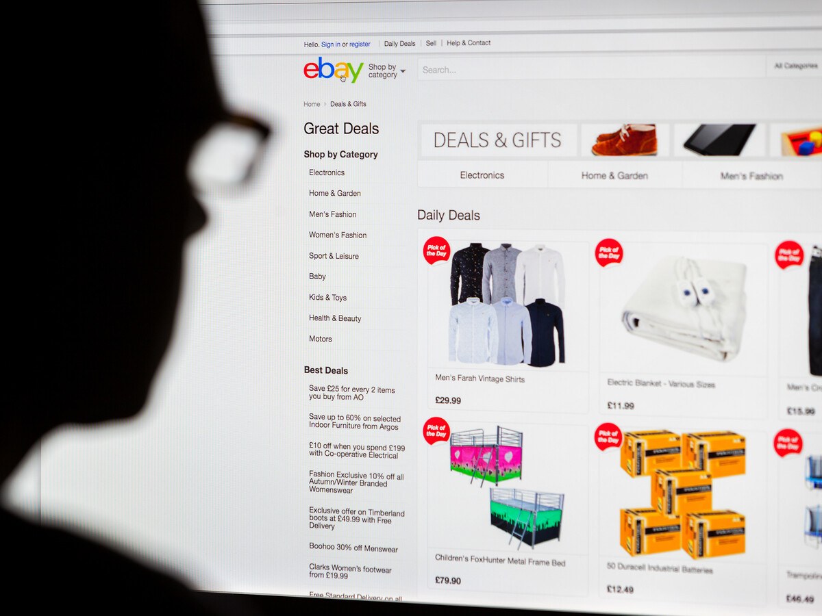 A person in glasses looking at a computer monitor at the eBay website.